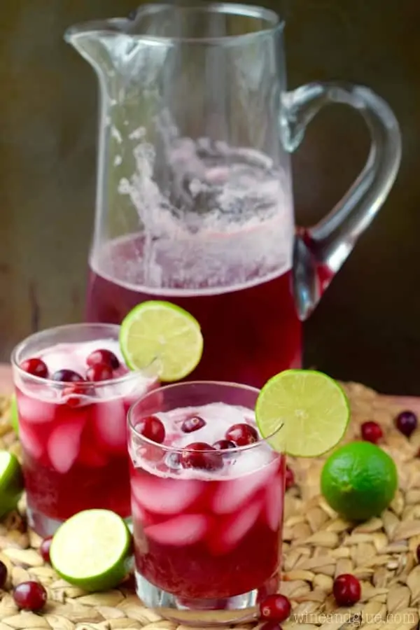Two glasses of Cranberry Beergaritas in front of the large pitcher. 