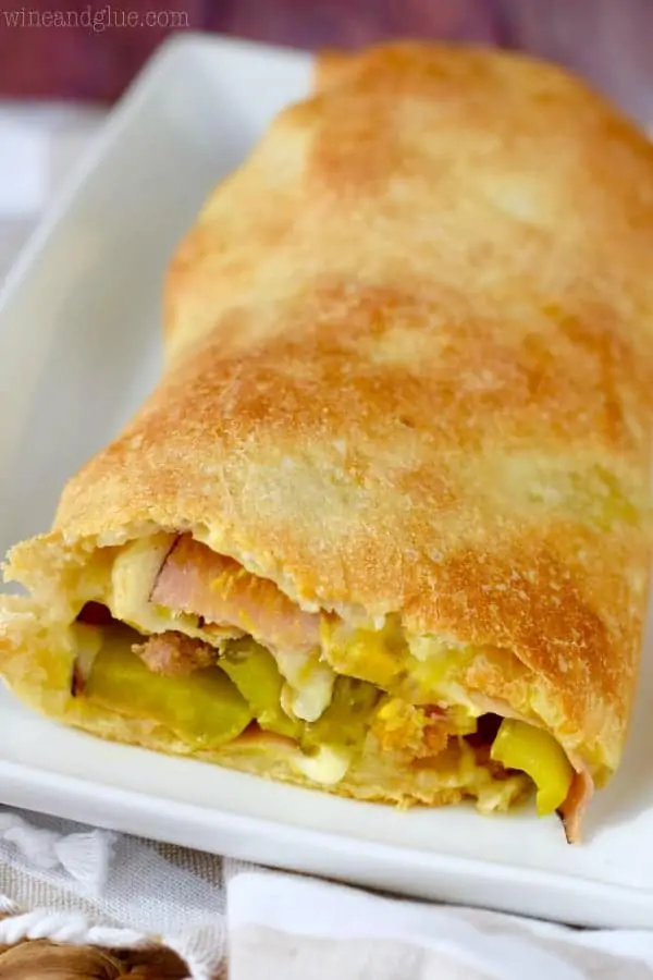 The Cuban Stromboli is cut showing the ham, Italian Sausage, pickles, Swiss cheese, and mustard.