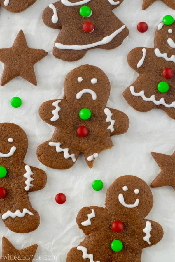An overhead photo of the Gingerbread Cookies shaped as a little person with the leg bitten off and a frowny face on the gingerbread cookie. 