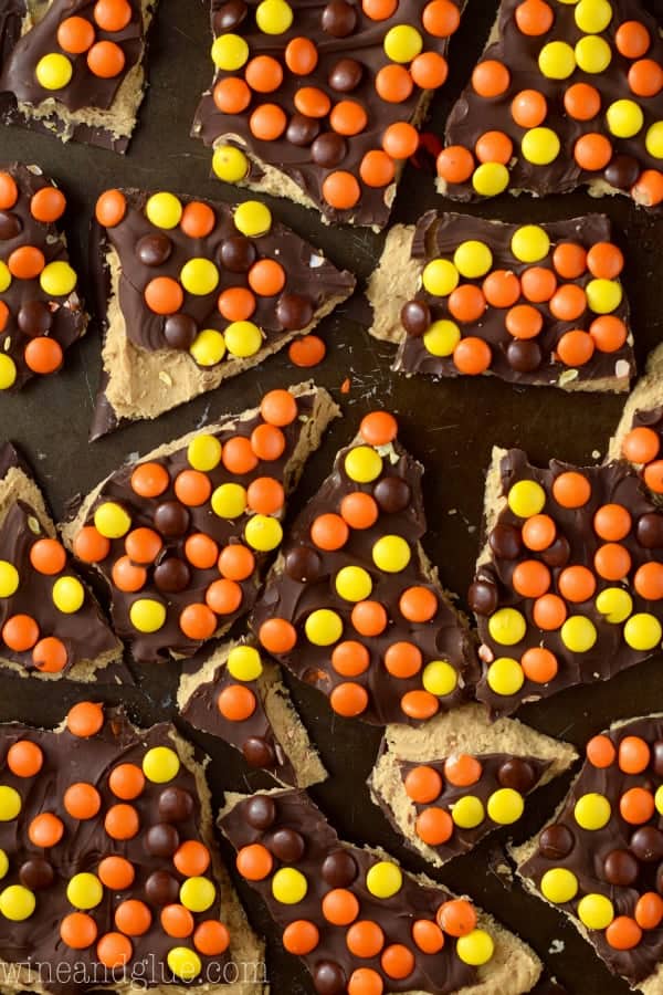 An overhead photo of the Loaded Reese's Peanut Butter Cup bark that is cut into little shards and topped with Reese's Pieces. 