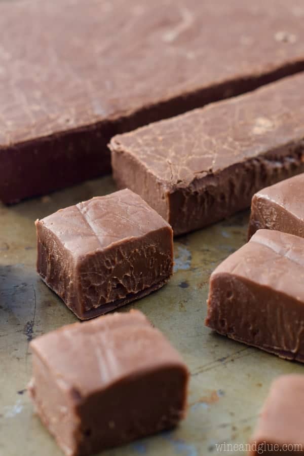 A block of the Nutella Fudge is being cut into long rectangular strips and then into little cubes. 