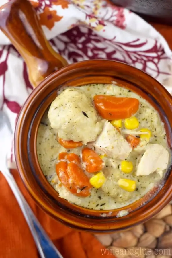 An overhead photo of the Turkey Dumpling Soup has chunks of turkey, balls of dumpling, slices of carrots, and corn in a creamy broth. 