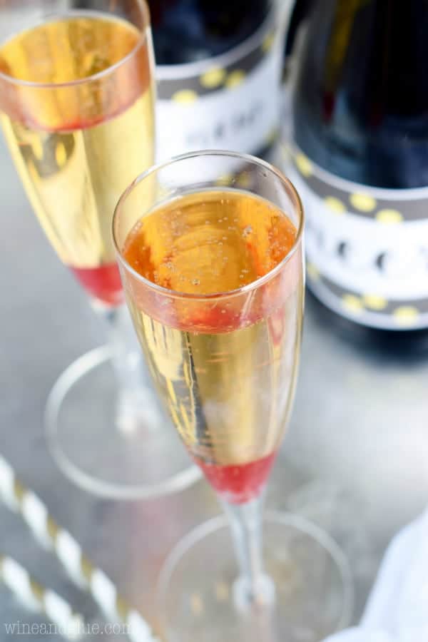 In a champagne fluke, the Amaretto Orange Bellini has a single maraschino cherry at the bottom and bubbling. 