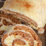 overhead photo of a cinnamon cake roll with a slice cut off
