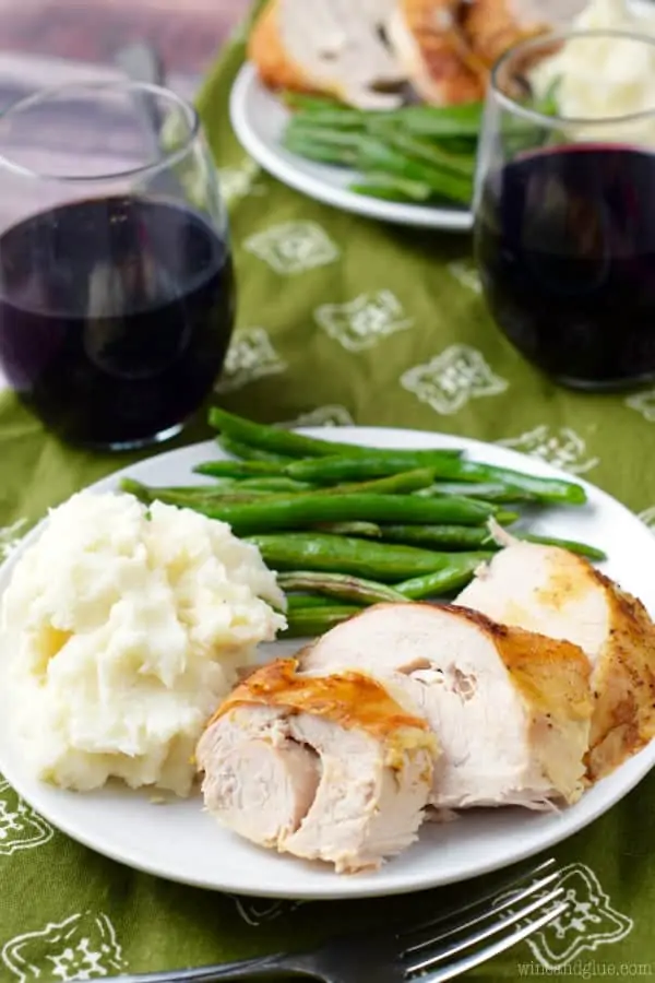 On a white plate, a hefty scoop of the Easy Ranch Potatoes is a side dish with green beans for a chicken entree. 
