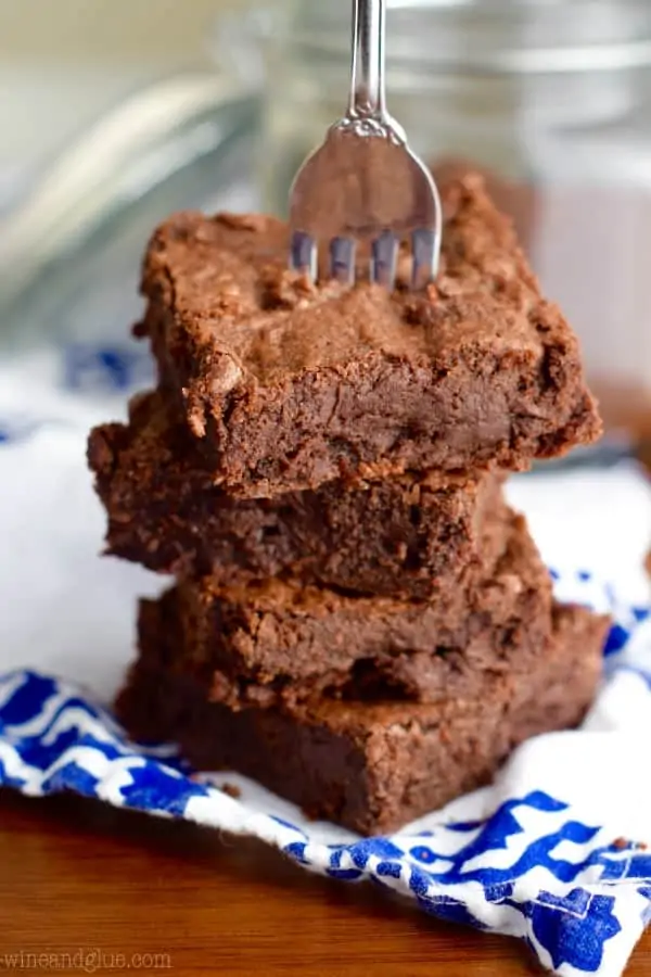 A fork is stabbing the Mocha Fudge Brownie stack. 