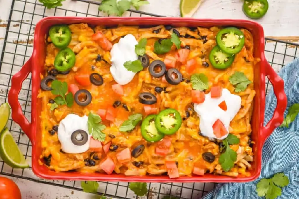 overhead of a taco casserole in a baking dish garnished with taco toppings