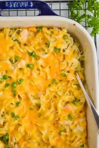 overhead view of a turkey noodle casserole in a ceramic baking dish with a spoon going in