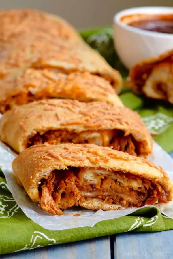 The BBQ Chicken Pizza Roll is cut into slices and has a golden brown crust with shreds of BBQ chicken inside. 