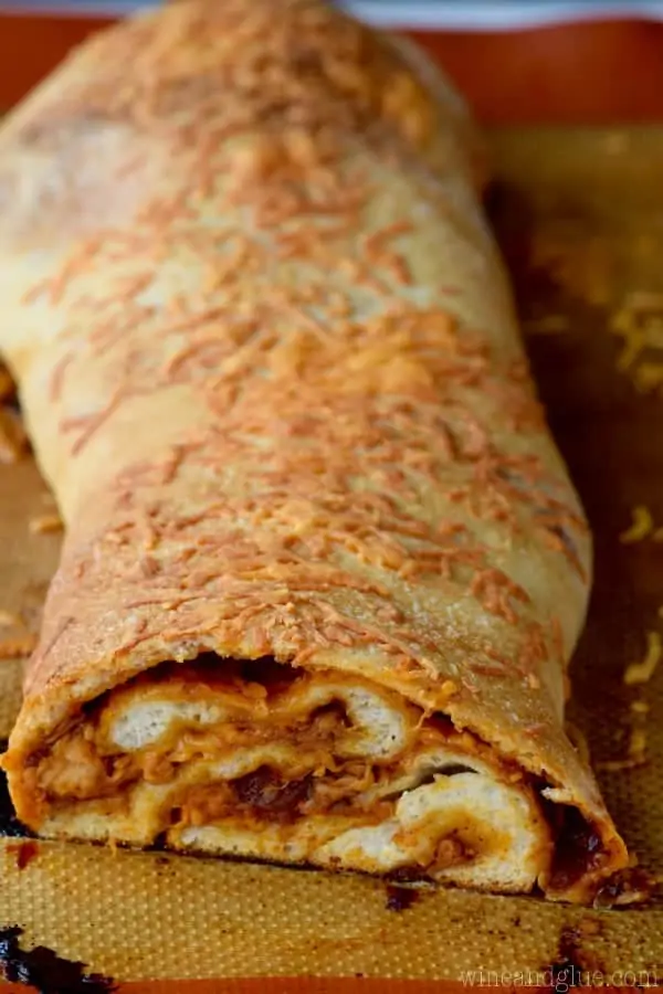 The BBQ Chicken Pizza Roll is cut into slices and has a golden brown crust with shreds of BBQ chicken inside. 