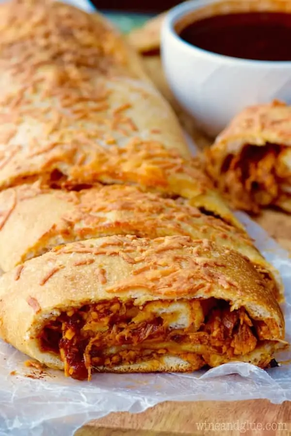 The BBQ Chicken Pizza Roll is cut into slices and has a golden brown crust with shreds of BBQ chicken inside. 