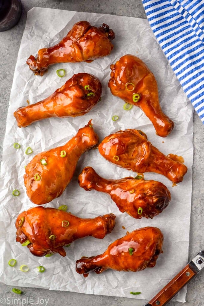 Overhead photo of Crock Pot Chicken Drumsticks laid out on parchment paper.