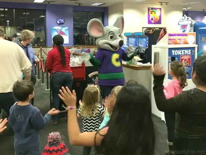 A picture of little children greeting Chuck E. Cheese. 