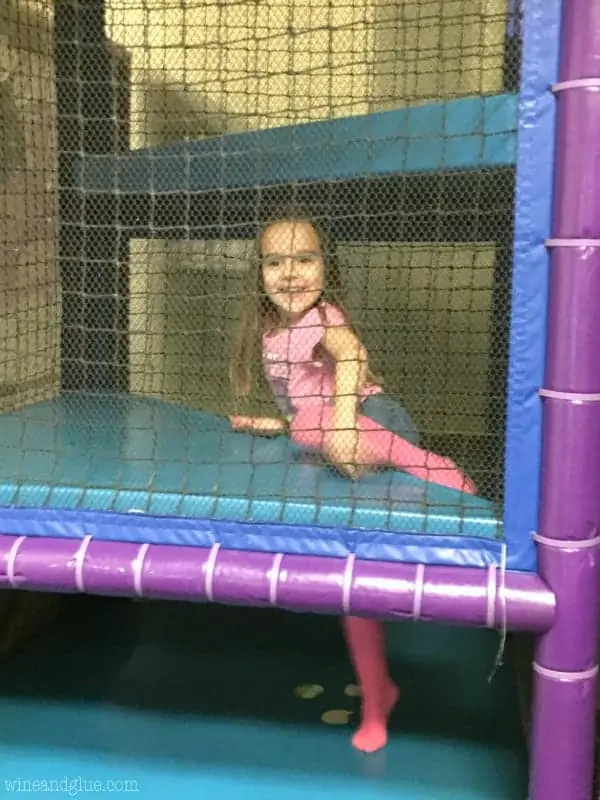 A little a girl climbing up a playground. 