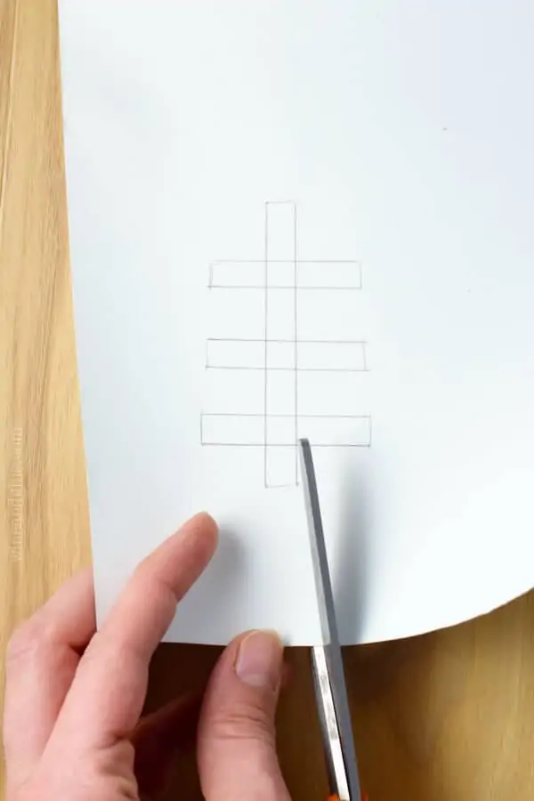 A woman cutting out the vertical line with three horizontal lines which is the football seam. 