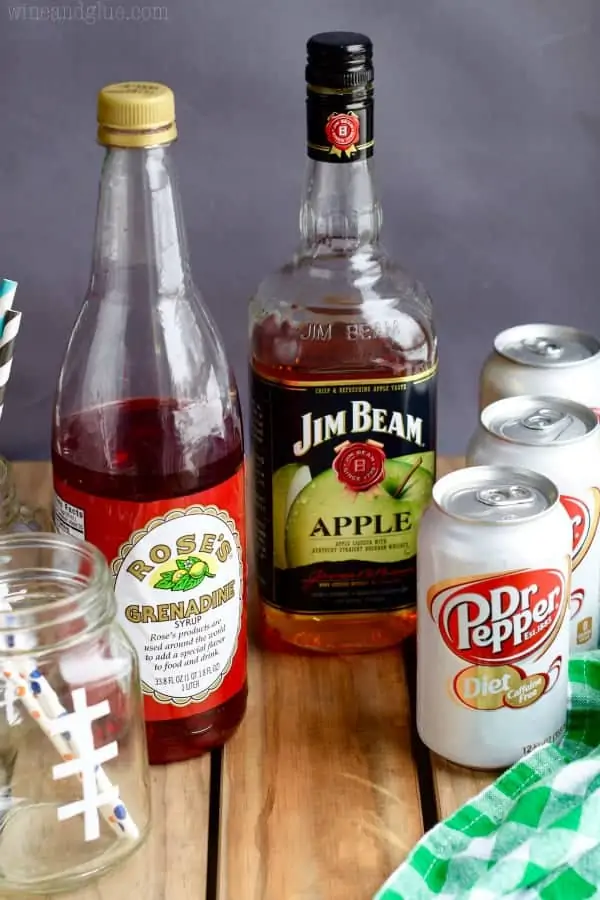 A photo of the ingredients of the Super Bowl Slammers (Grenadine, Apple Bourbon, and Dr. Pepper). 