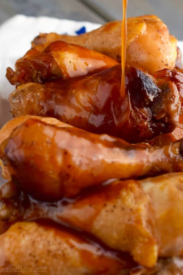 Honey BBQ sauce is being poured onto the crispy chicken wings. 