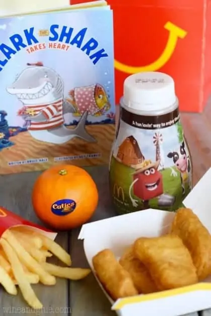 A photo of a children's meal from Mcdonalds with 4 Chicken McNuggets, Cuties, fries, and milk. 
