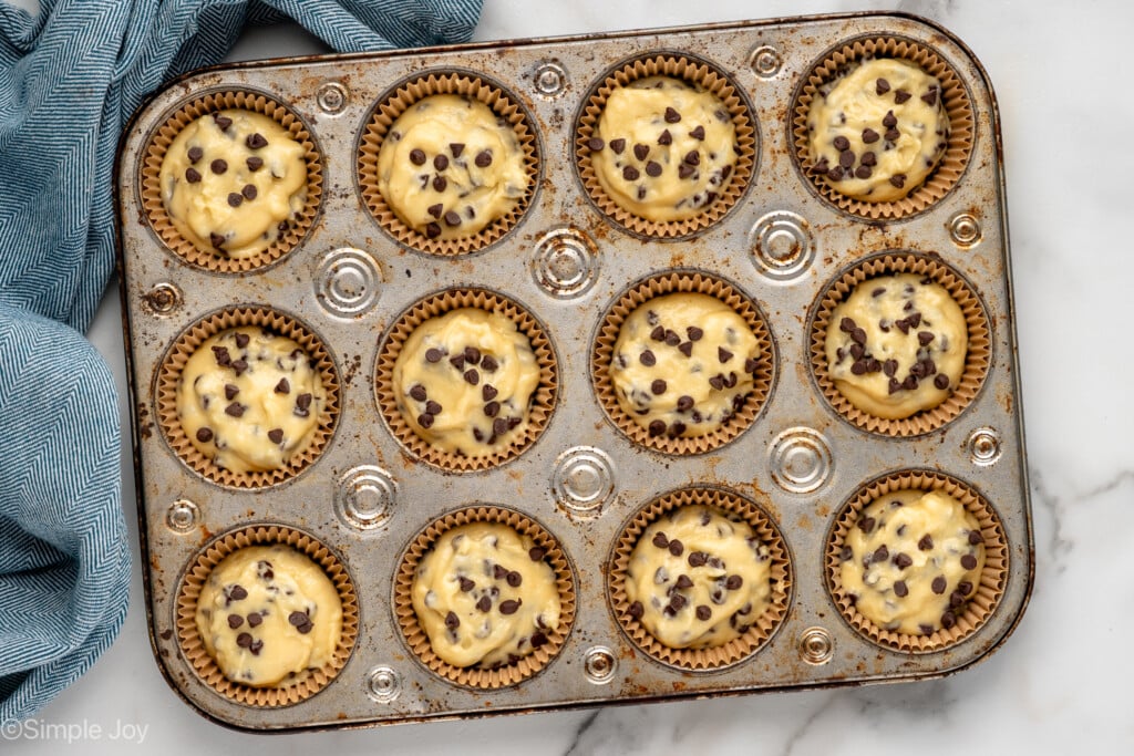 overhead of a muffin tin with unbaked chocolate chip muffins - 8
