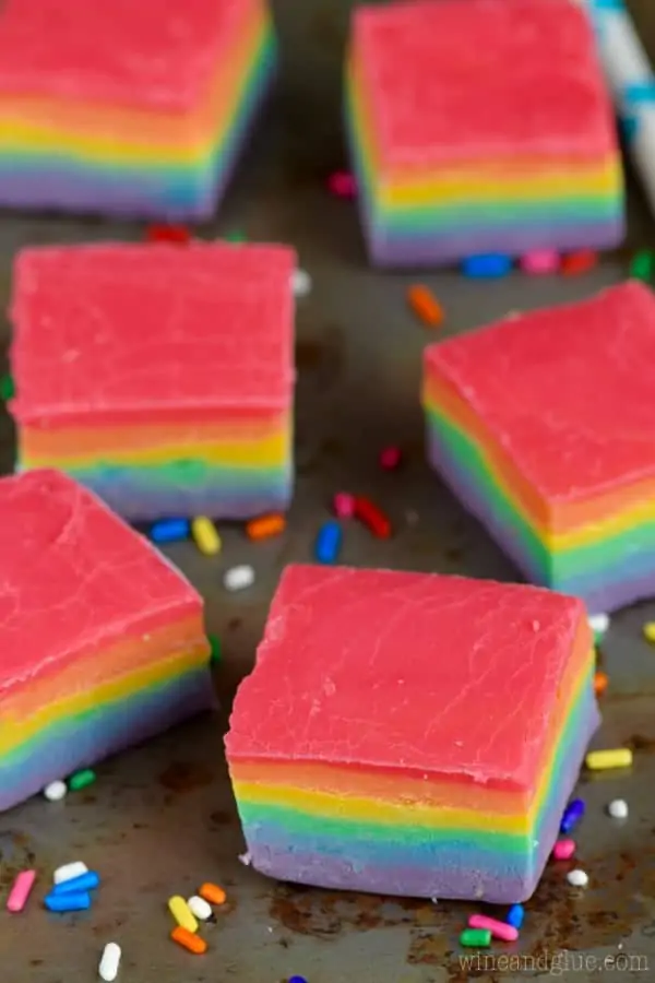 The Rainbow Fudge is on a baking sheet in cube shapes showing the distinct layers of red, orange, yellow, green, blue, and purple (in that order). 