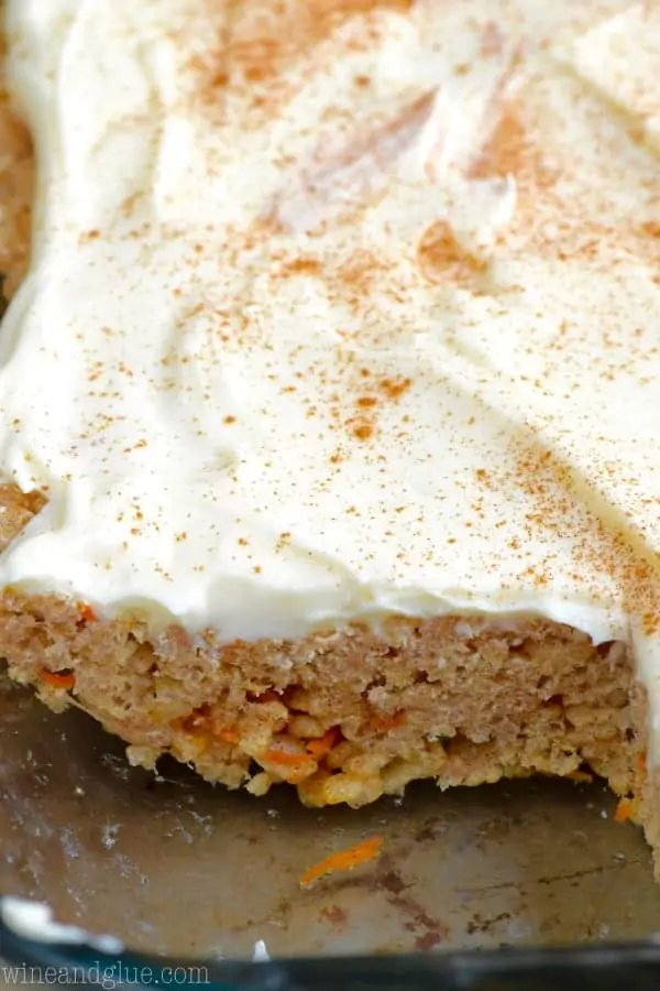 In a a glass casserole dish, the Carrot Cake Rice Krispies has a small slice that was cut out showing the little shreds of carrot that is mixed in with the rice krispies. 