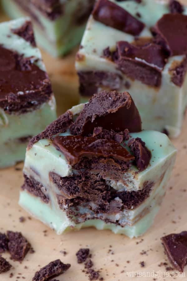 A bite is taken out of the Grasshopper Fudge showing a mint green tint with speckles of the grasshopper cookies. 
