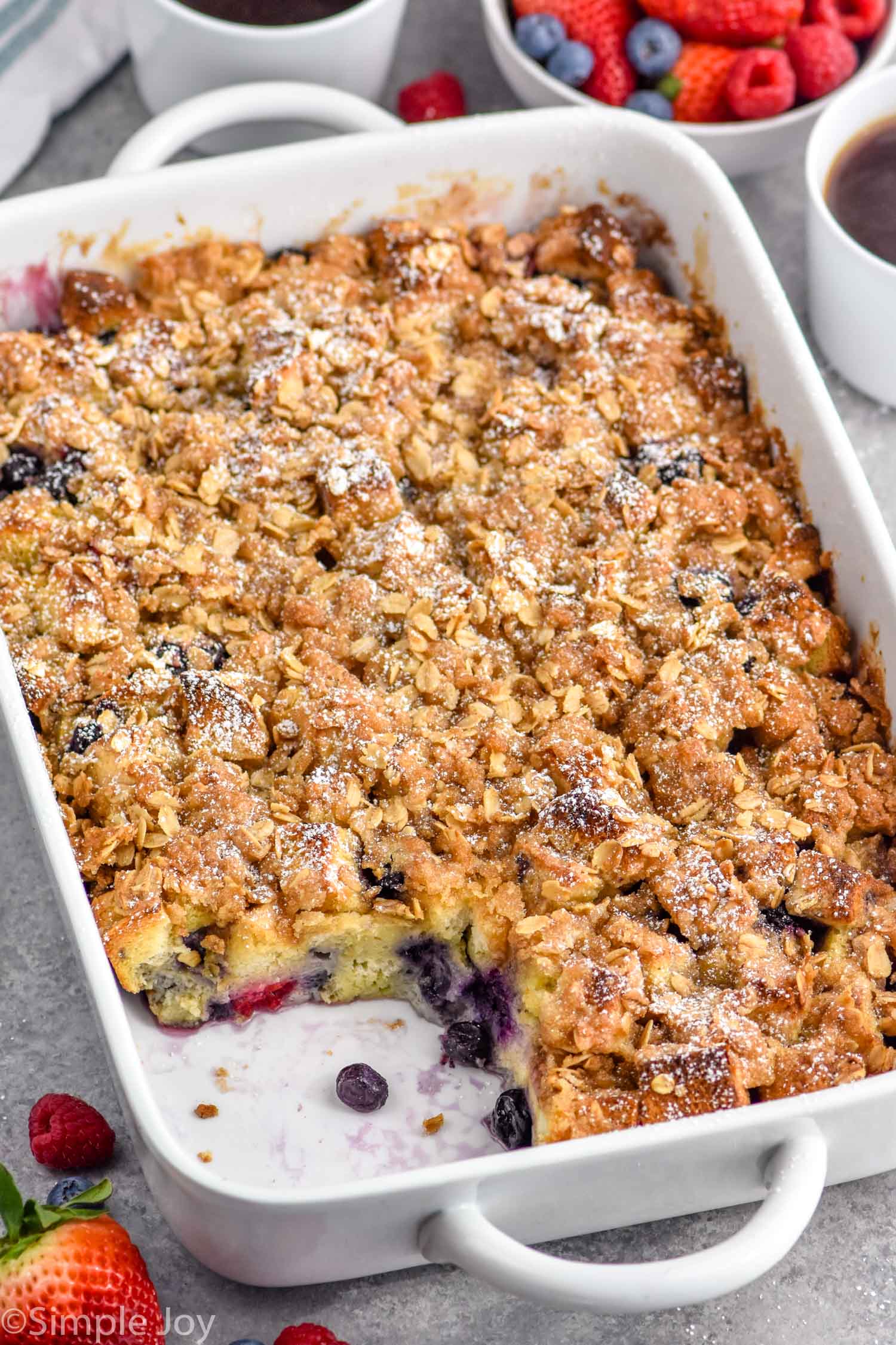 Overhead photo of a baking dish of Berry French Toast Casserole with a piece missing.