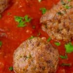 close up of an Italian meatball on red sauce