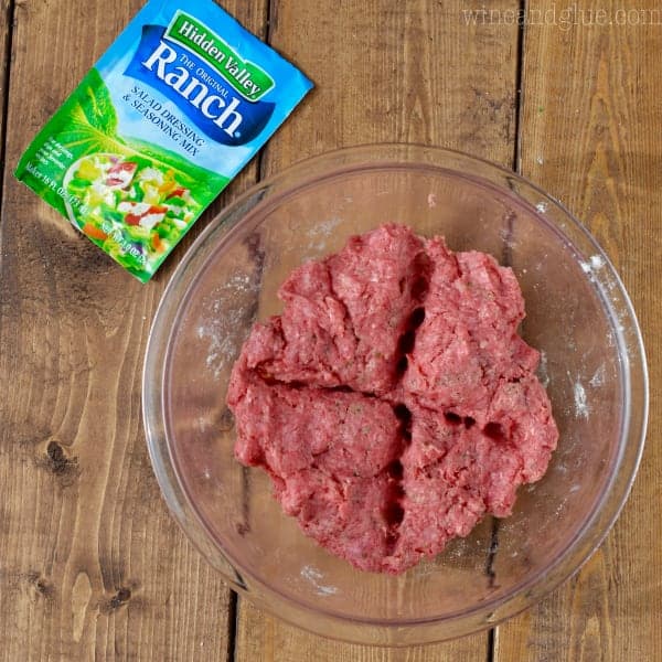 After the Hidden Valley Ranch Powder packet has been thoroughly mixed within the ground beef, the mixture is divided into fourths. 
