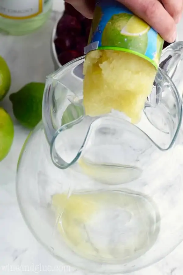 Frozen Limeade is being poured into a large pitcher. 