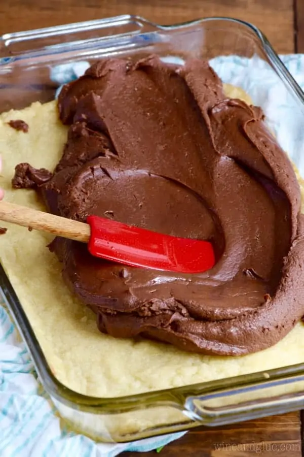 fudge layer being spread out over a cookie layer of bars