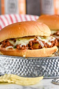 Close up photo of Italian Sloppy Joe sandwich. Potato chips on the side.