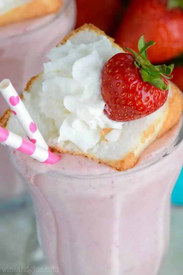 A closeup photo of the fluffy shortcake topped with whipped cream and strawberry. 