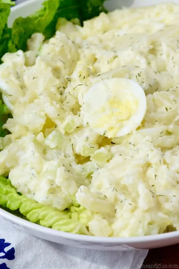 In a bowl, the Lighter Potato Salad with white onions and eggs and topped with dill. 
