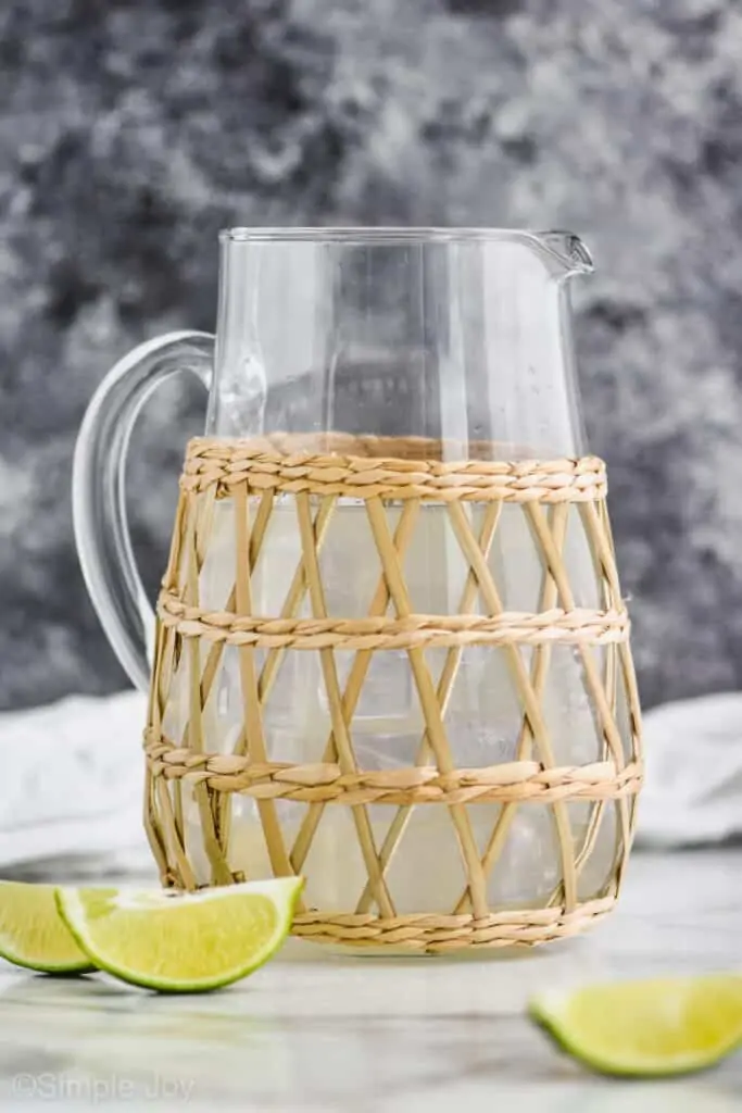 glass pitcher with a straw outside holder that has homemade margaritas in it