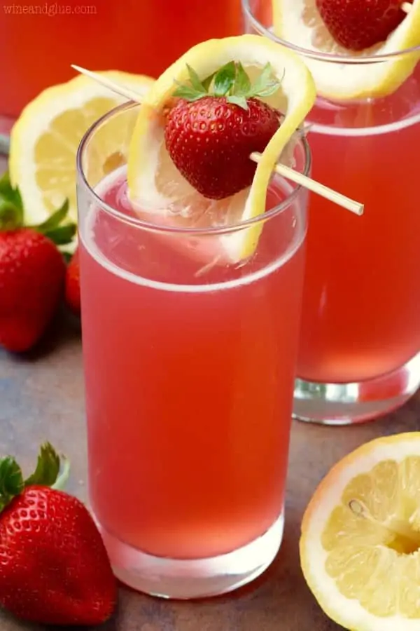 The Strawberry Lemonade Beergaritas is in in a tall glass and topped with a sliced lemon covering a strawberry in a toothpick. 