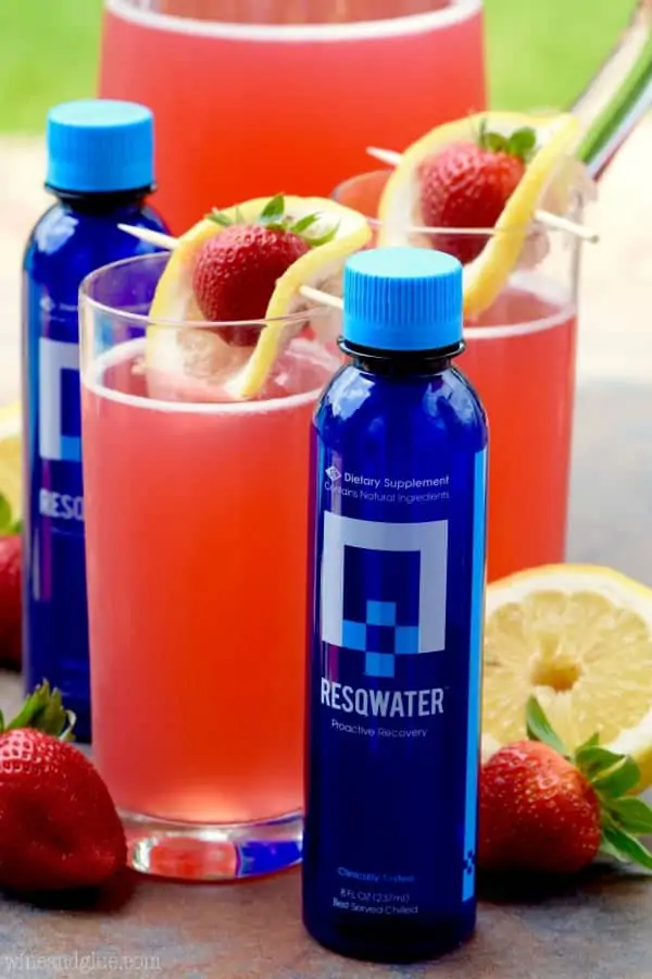 The glass of Strawberry Lemonade Beergaritas are in between two bottles of Resqwater. 
