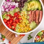 pinterest graphic of overhead photo of a southwestern steak salad separated by ingredients in a bowl