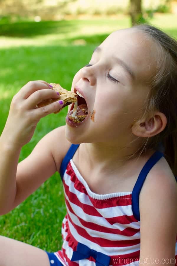 A little girl eating the Candy Coated S'mores showing the gooey center. 