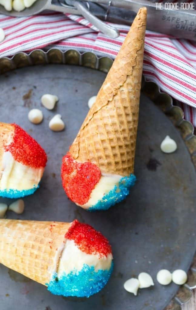 An overhead photo of the Red White and Blue Drumsticks are in ice cream cones and sprinkled with red and blue sugar. 