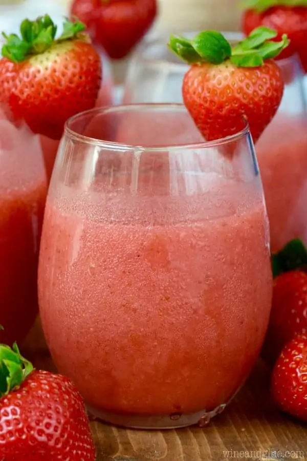In a wine glass, the Strawberry Daiquiri Sangria has a slushy like consistency with a red coloring. 