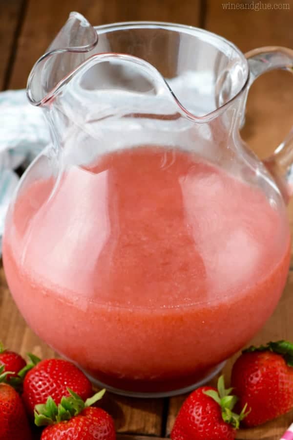 In a glass pitcher, the Strawberry Daiquiri Sangria has a frosted red coloring. 
