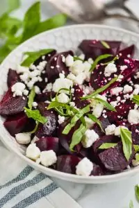 white bowl filled with easy beet salad of roasted beets, feta cheese, and fresh basil