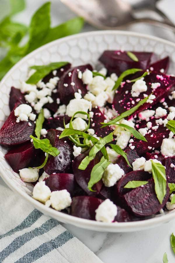 white bowl filled with easy beet salad of roasted beets, feta cheese, and fresh basil