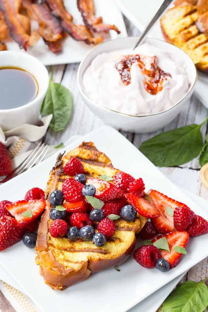 The Grilled French Toast has grilled marks on it and topped with raspberries, blueberries, and strawberries. 