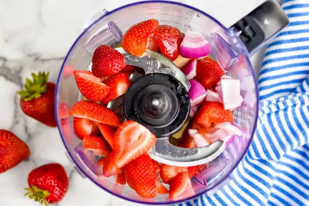 halved strawberries and other ingredients in a food processor to make salad dressing