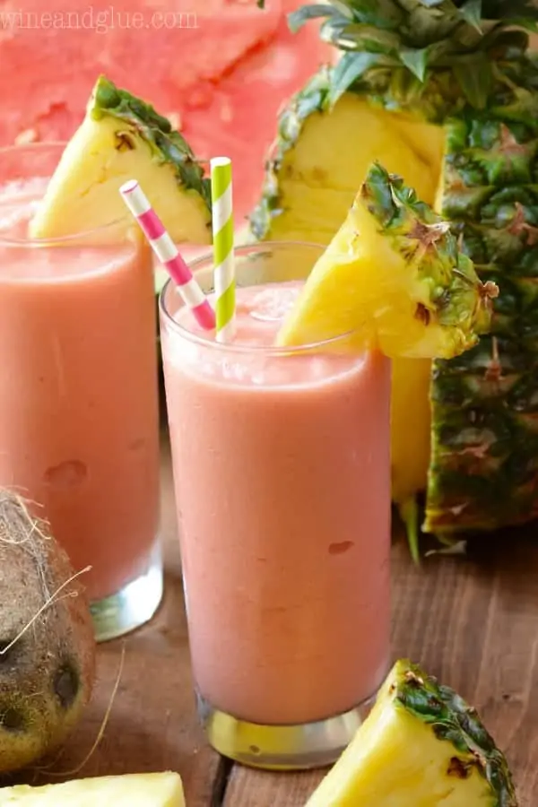 The Watermelon Pina Colada has a pink tint and a slice of pineapple on the rim. 