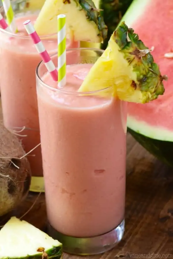 The Watermelon Pina Colada has a pink tint and a slice of pineapple on the rim. 