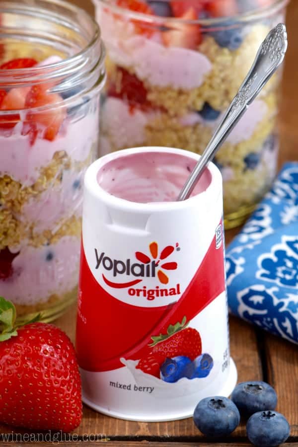A Yoplait Original Mixed Berry yogurt cup has a spoon coming out of it. 