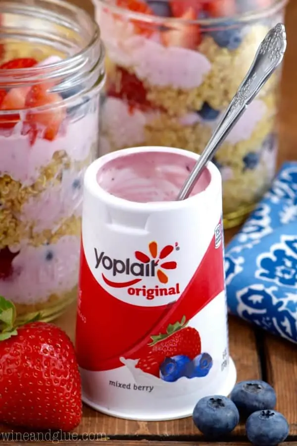 A Yoplait Original Mixed Berry yogurt cup has a spoon coming out of it. 